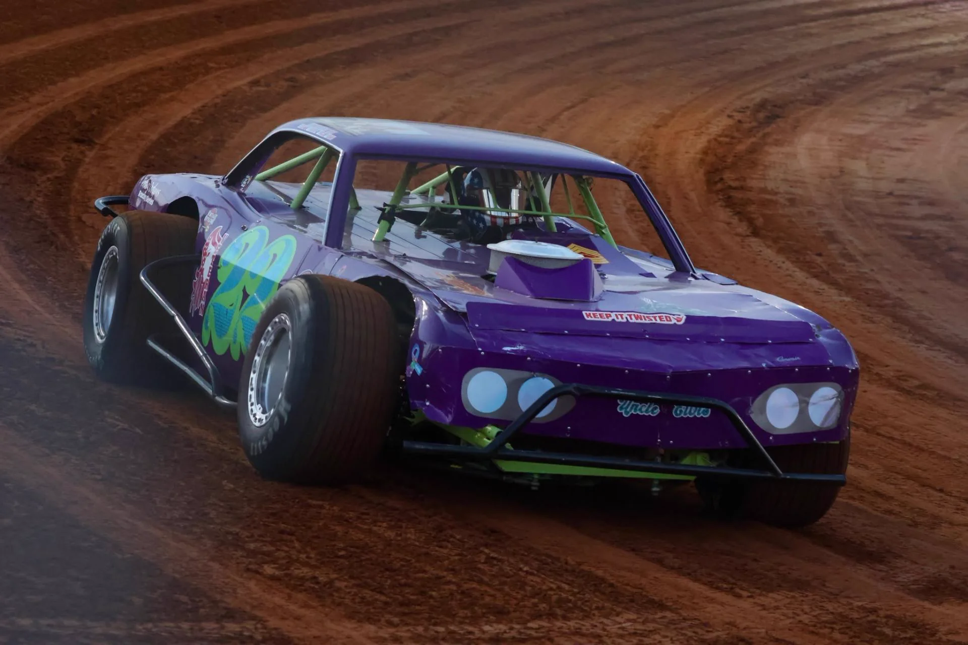 Purple #22 vintage modified slinging dirt through a corner